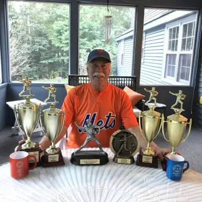 Brian Martel Sits with His Trophies. He attributes his success to Yoga.